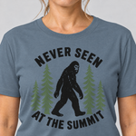 Nahaufnahme des Drucks: Never seen at the summit – T-Shirt Unisex in Steinblau, von einer Frau getragen