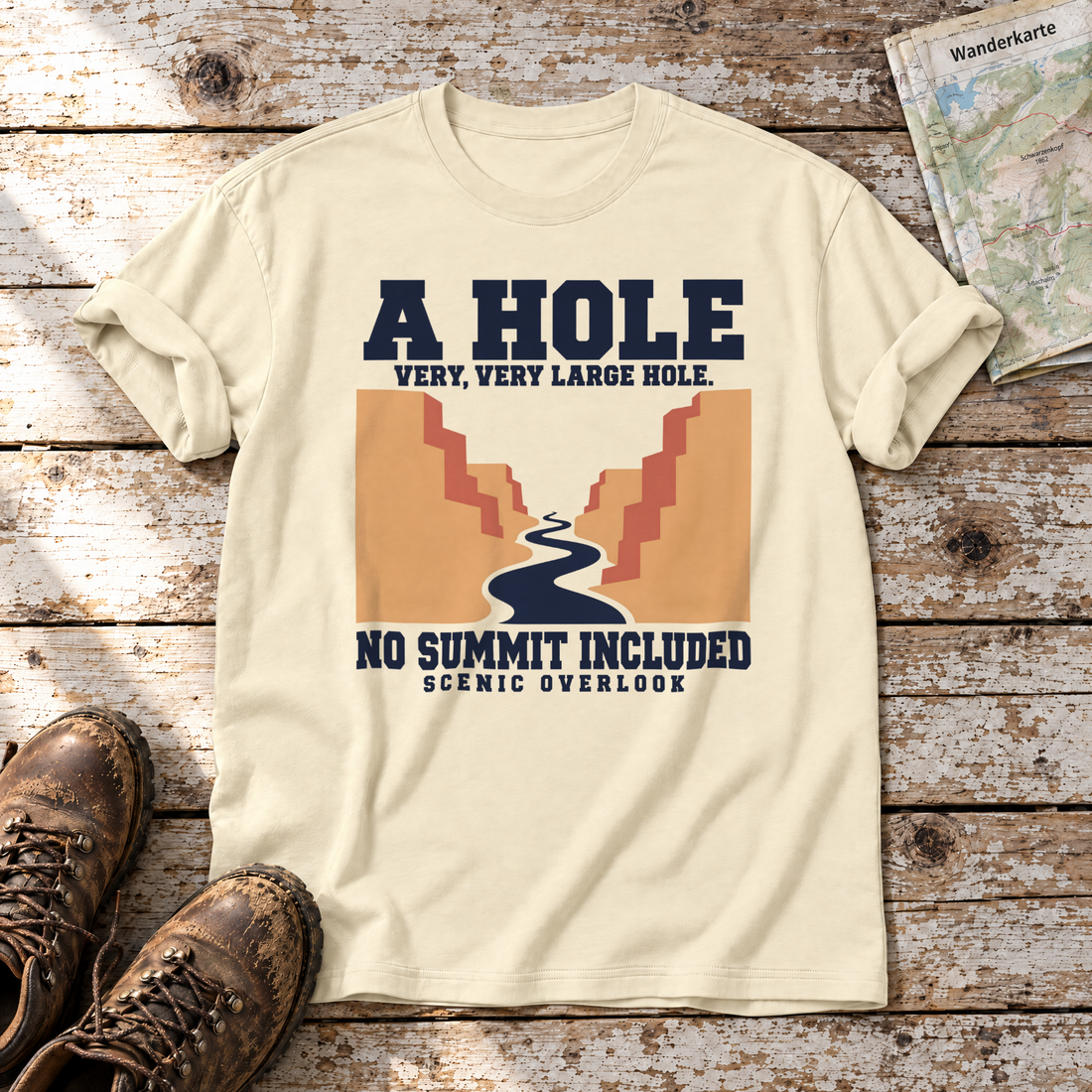 No Summit Included – T-Shirt Unisex in Natur, flach liegend auf alten Holzbrettern mit Wanderschuhen und Wanderkarte.