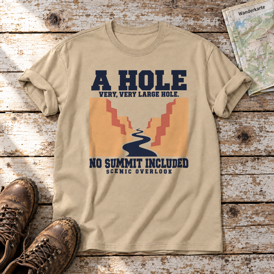 No Summit Included – T-Shirt Unisex in Sand, flach liegend auf alten Holzbrettern mit Wanderschuhen und Wanderkarte.