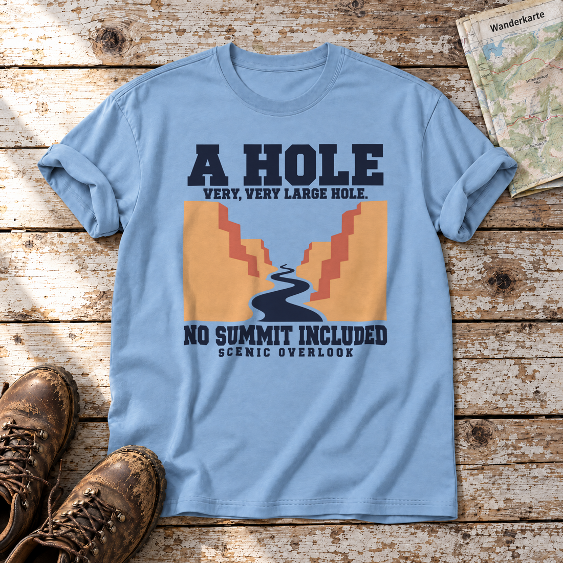 No Summit Included – T-Shirt Unisex in Himmelblau, flach liegend auf alten Holzbrettern mit Wanderschuhen und Wanderkarte.