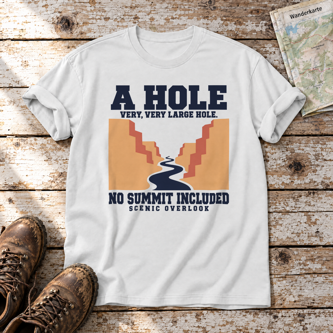 No Summit Included – T-Shirt Unisex in Weiß, flach liegend auf alten Holzbrettern mit Wanderschuhen und Wanderkarte.