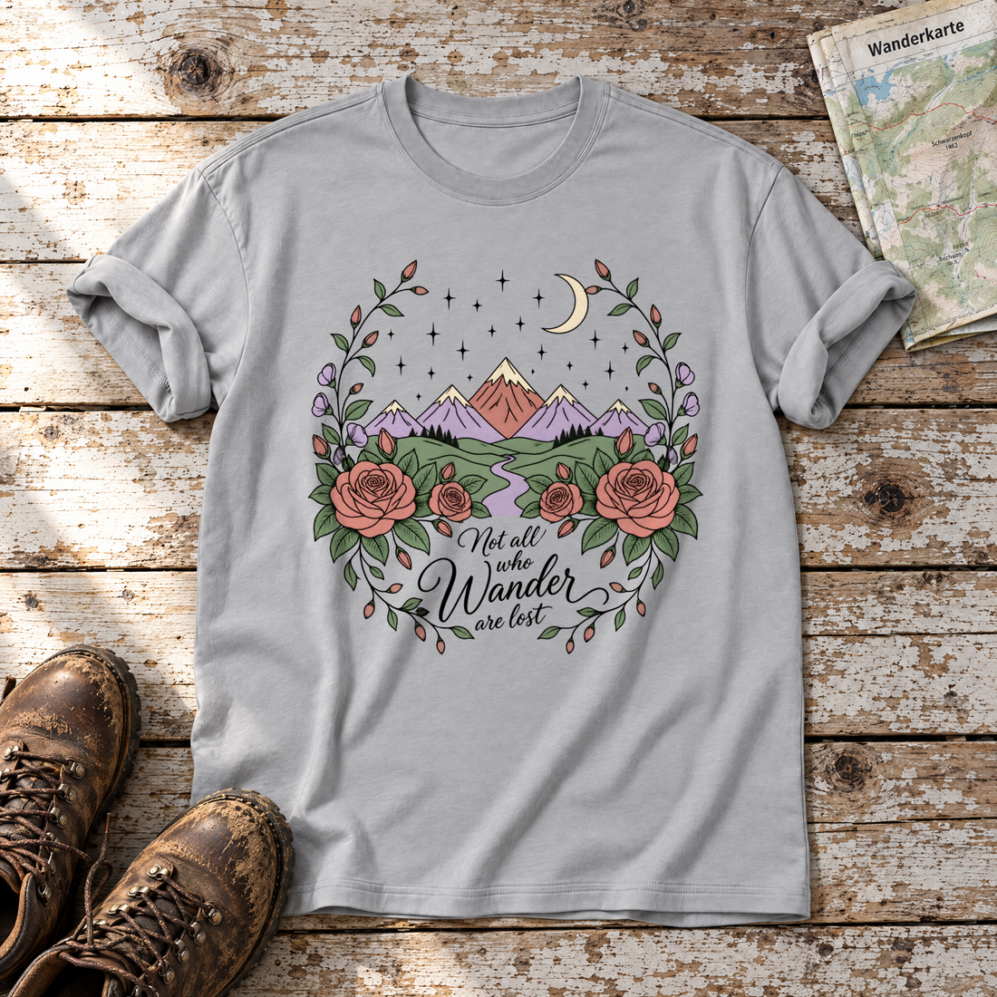 Not all who Wander are lost – T-Shirt Unisex in Hellgrau, flach liegend auf alten Holzbrettern mit Wanderschuhen und Wanderkarte.