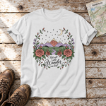 Not all who Wander are lost – T-Shirt Unisex in Weiß, flach liegend auf alten Holzbrettern mit Wanderschuhen und Wanderkarte.