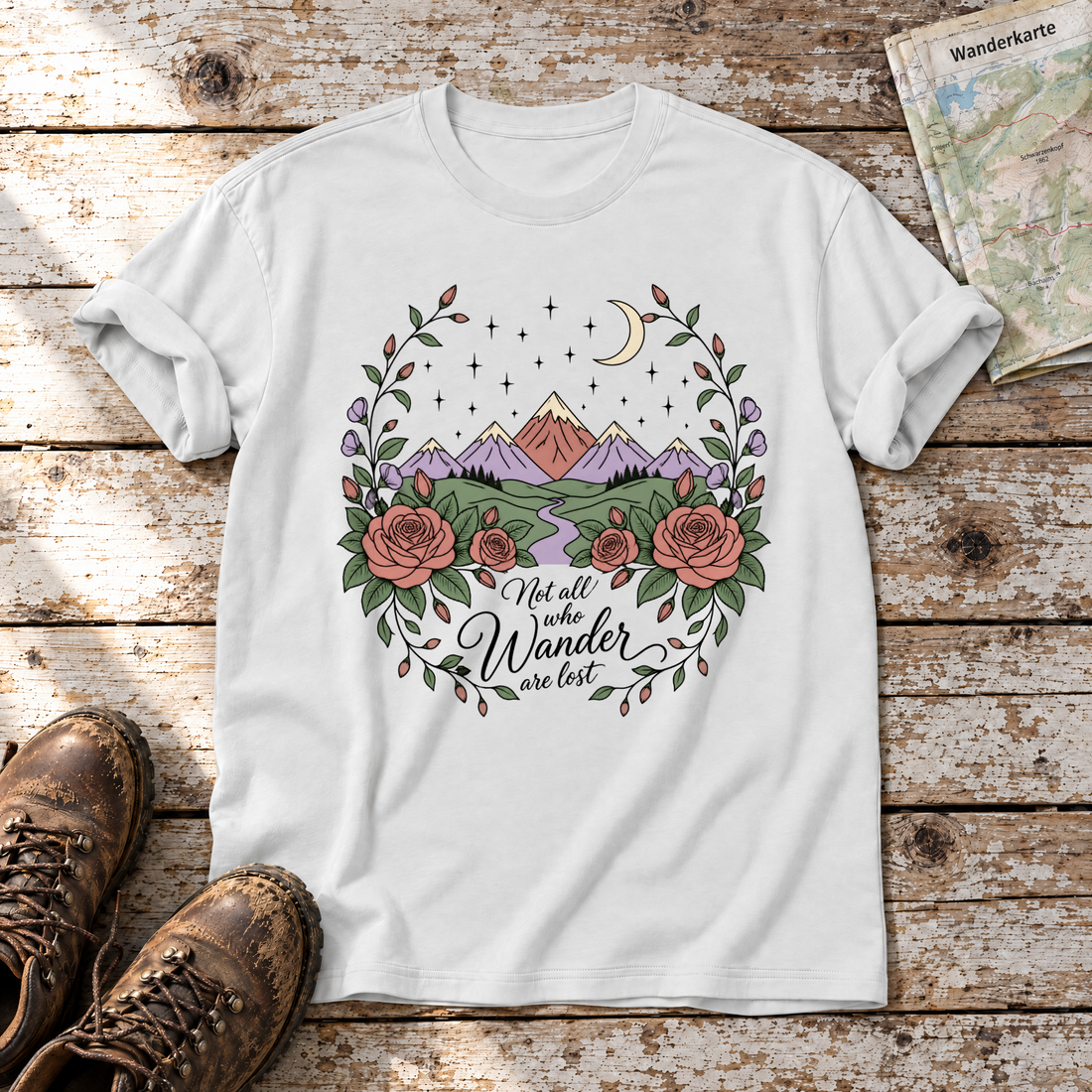 Not all who Wander are lost – T-Shirt Unisex in Weiß, flach liegend auf alten Holzbrettern mit Wanderschuhen und Wanderkarte.
