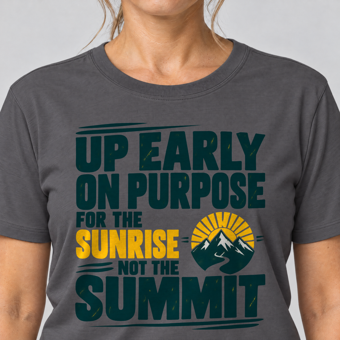 Nahaufnahme des Drucks: For the Sunrise, Not the Summit – T-Shirt Unisex in Dunkelgrau, von einer Frau getragen