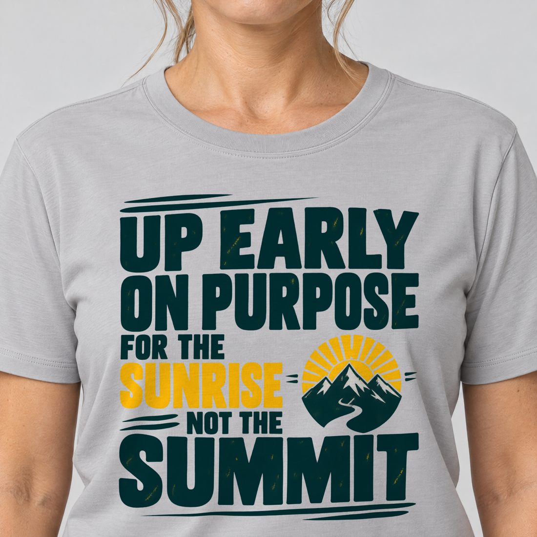 Nahaufnahme des Drucks: For the Sunrise, Not the Summit – T-Shirt Unisex in Hellgrau, von einer Frau getragen