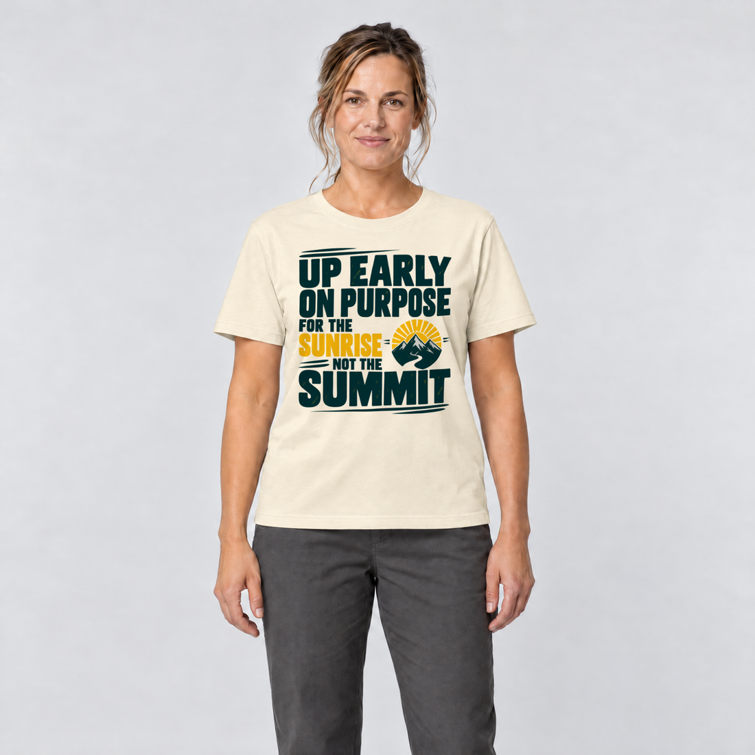 Frau trägt For the Sunrise, Not the Summit – T-Shirt Unisex in Natur, Ansicht von vorn