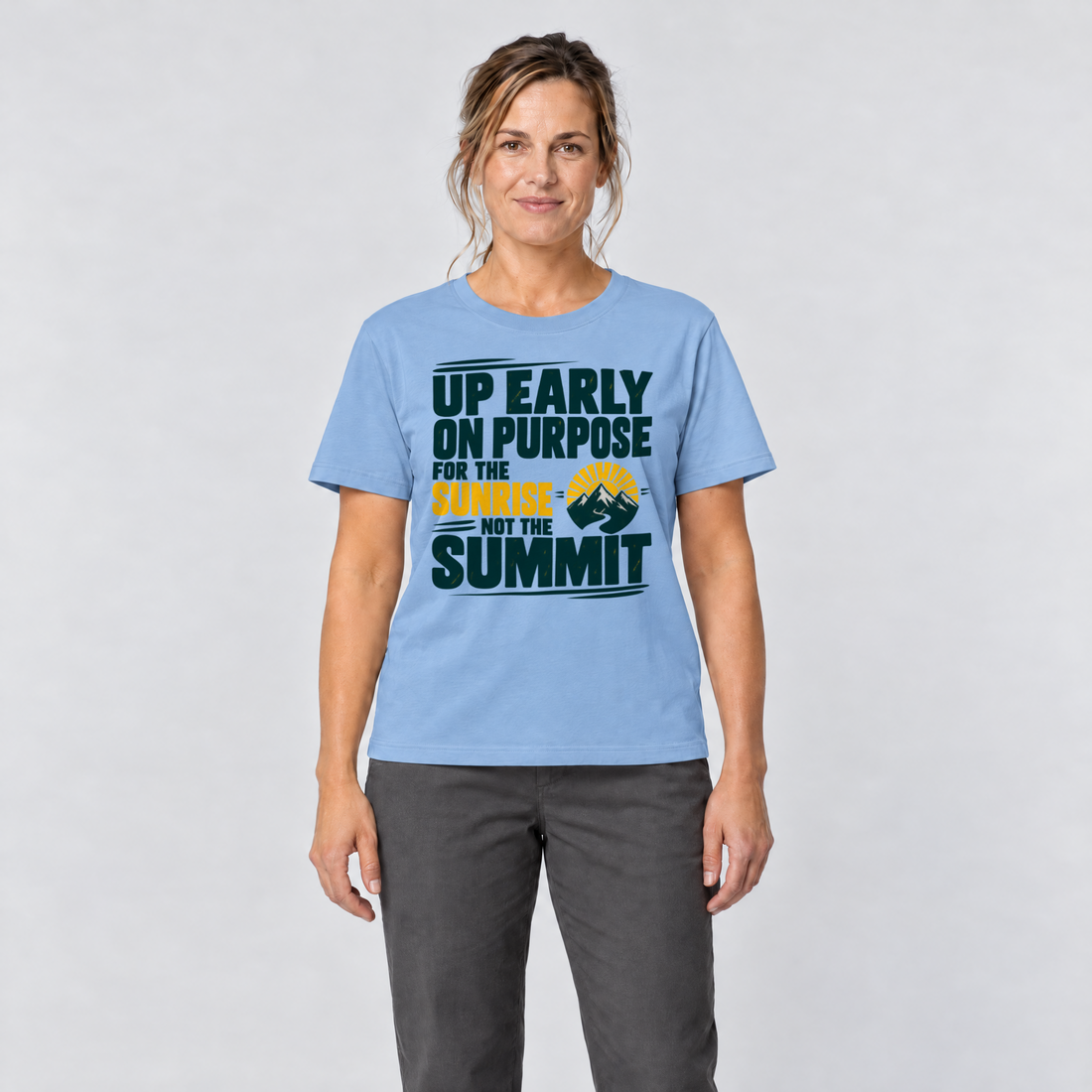 Frau trägt For the Sunrise, Not the Summit – T-Shirt Unisex in Himmelblau, Ansicht von vorn