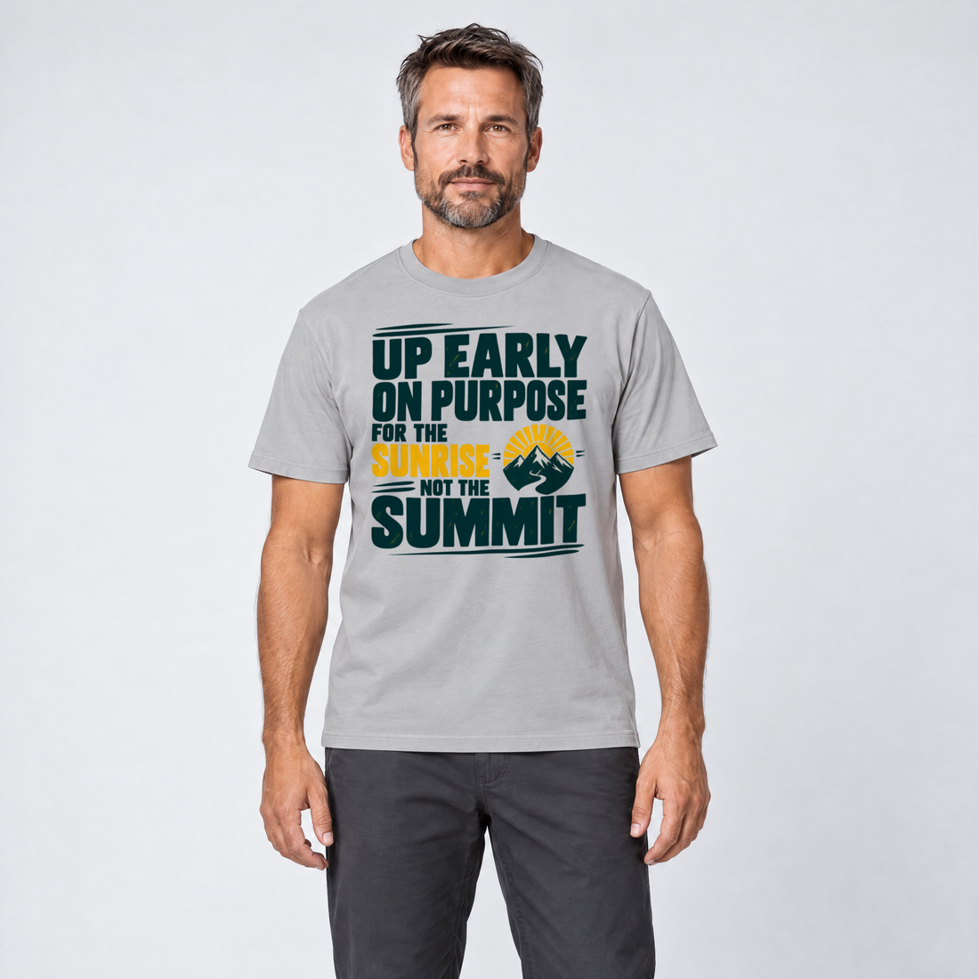 Mann trägt For the Sunrise, Not the Summit – T-Shirt Unisex in Hellgrau, Ansicht von vorn