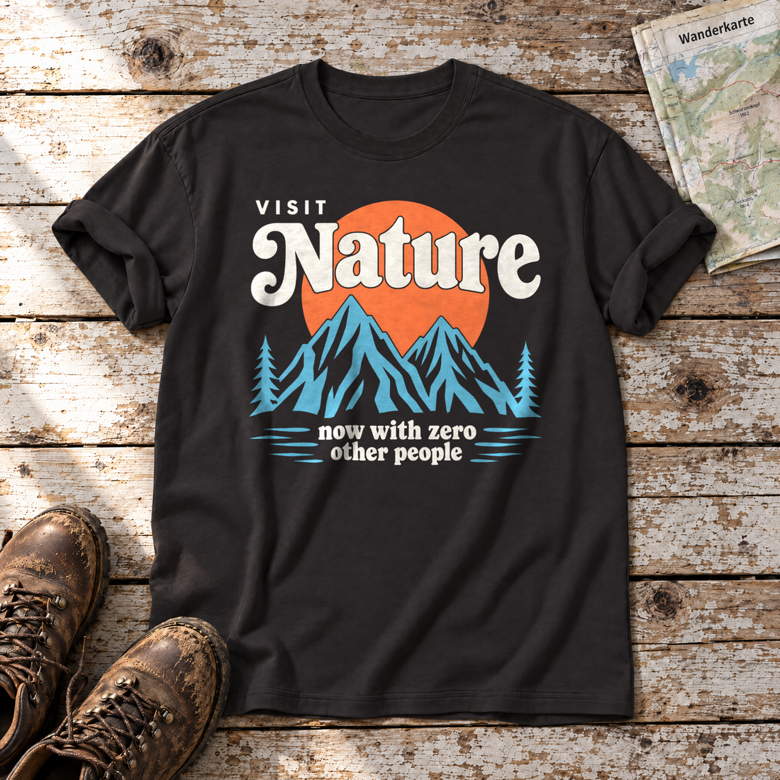 Now with zero other people – T-Shirt Unisex in Schwarz, flach liegend auf alten Holzbrettern mit Wanderschuhen und Wanderkarte.