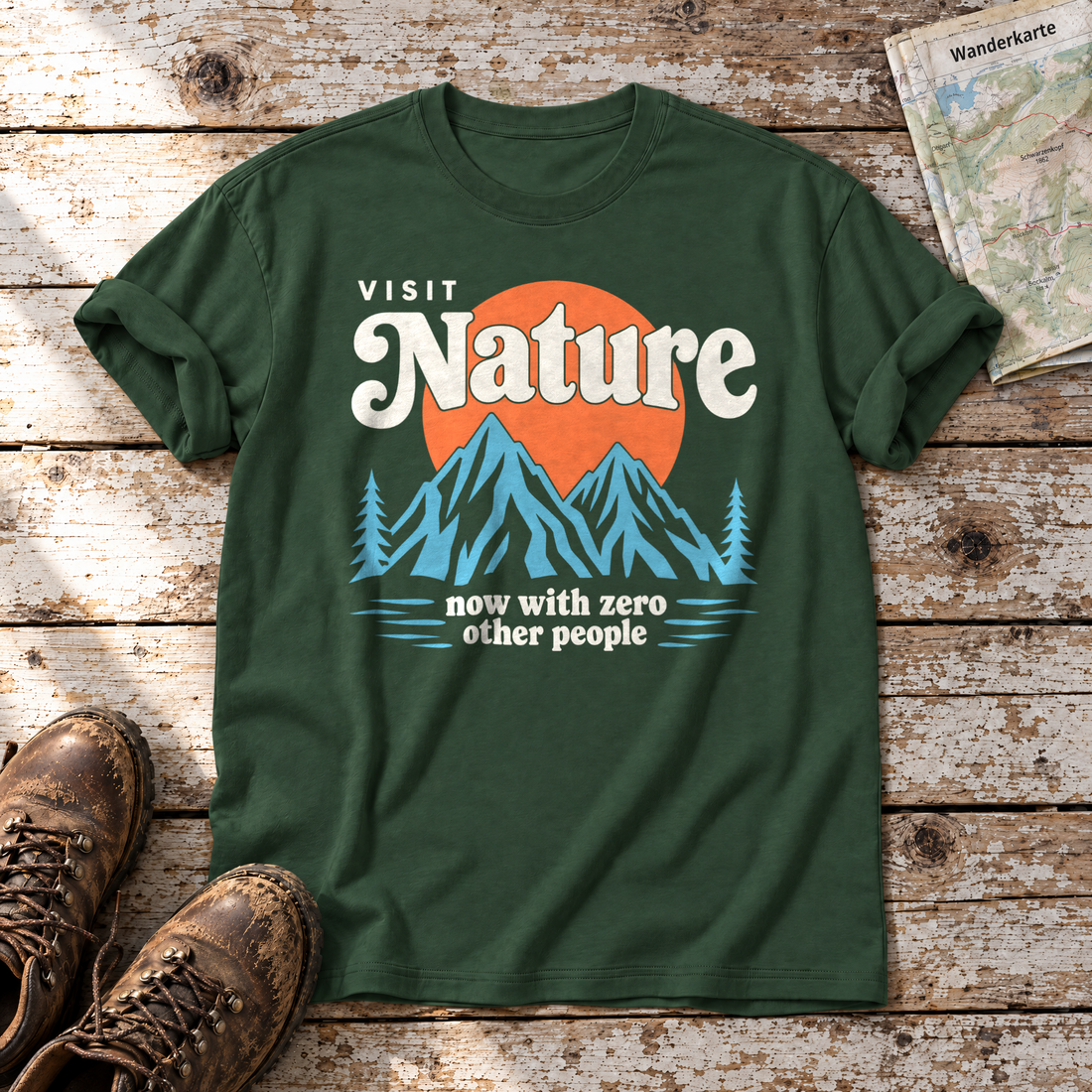 Now with zero other people – T-Shirt Unisex in Flaschengrün, flach liegend auf alten Holzbrettern mit Wanderschuhen und Wanderkarte.