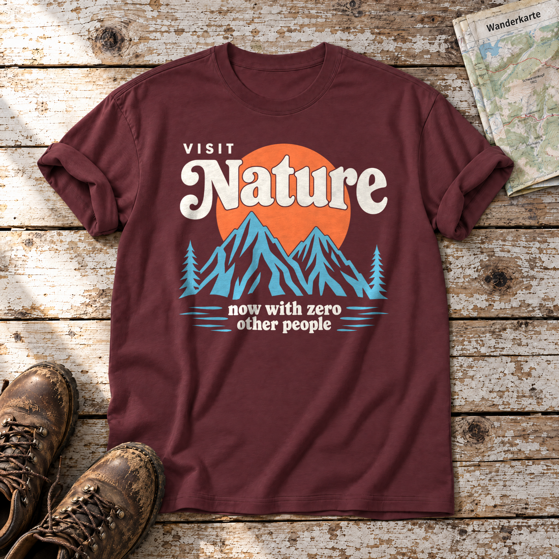 Now with zero other people – T-Shirt Unisex in Bordeaux, flach liegend auf alten Holzbrettern mit Wanderschuhen und Wanderkarte.