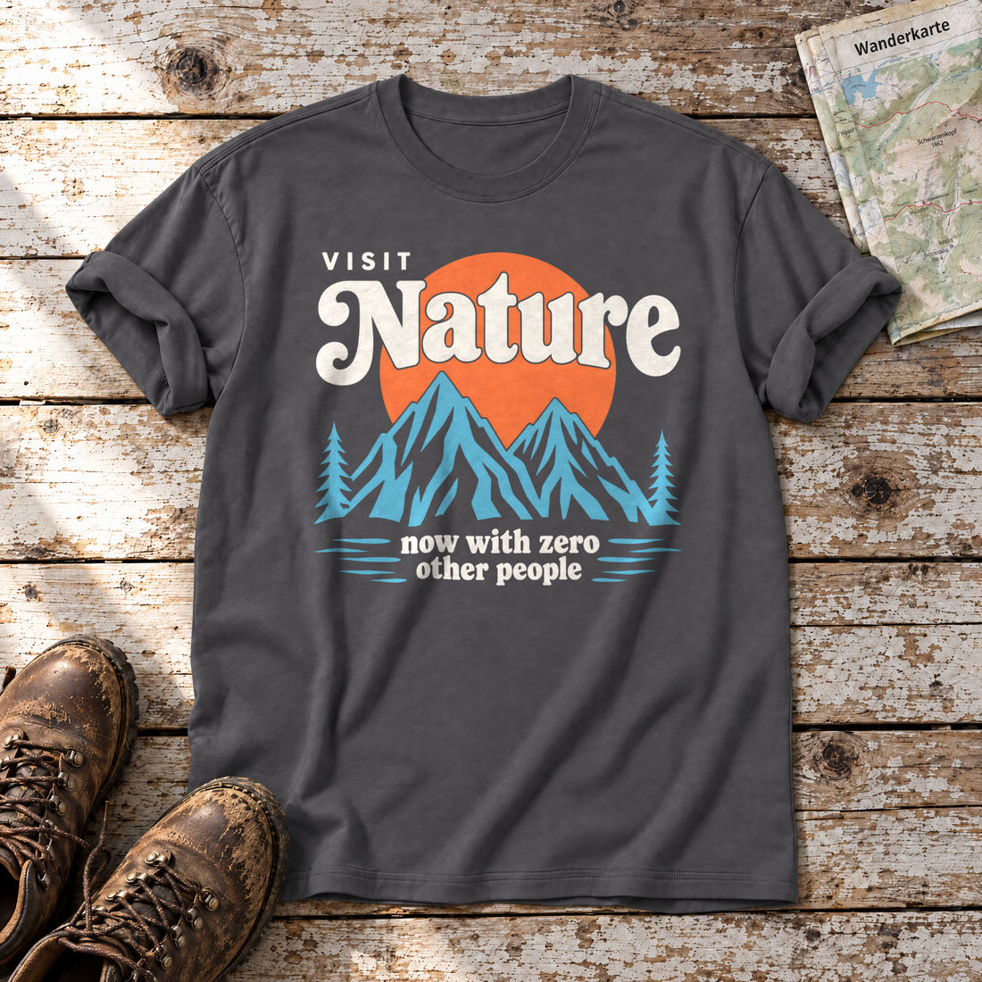 Now with zero other people – T-Shirt Unisex in Dunkelgrau, flach liegend auf alten Holzbrettern mit Wanderschuhen und Wanderkarte.