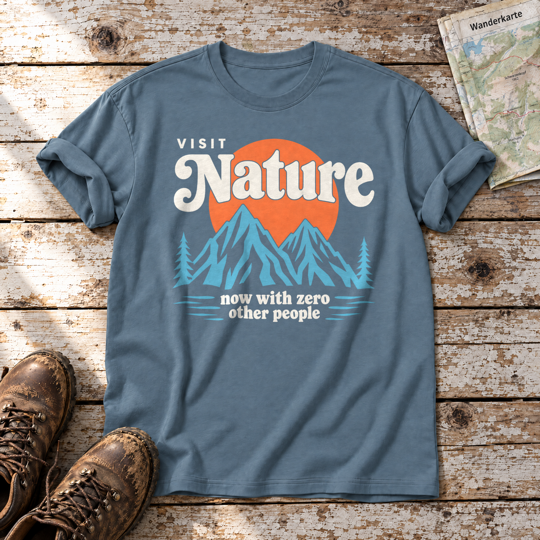 Now with zero other people – T-Shirt Unisex in Steinblau, flach liegend auf alten Holzbrettern mit Wanderschuhen und Wanderkarte.