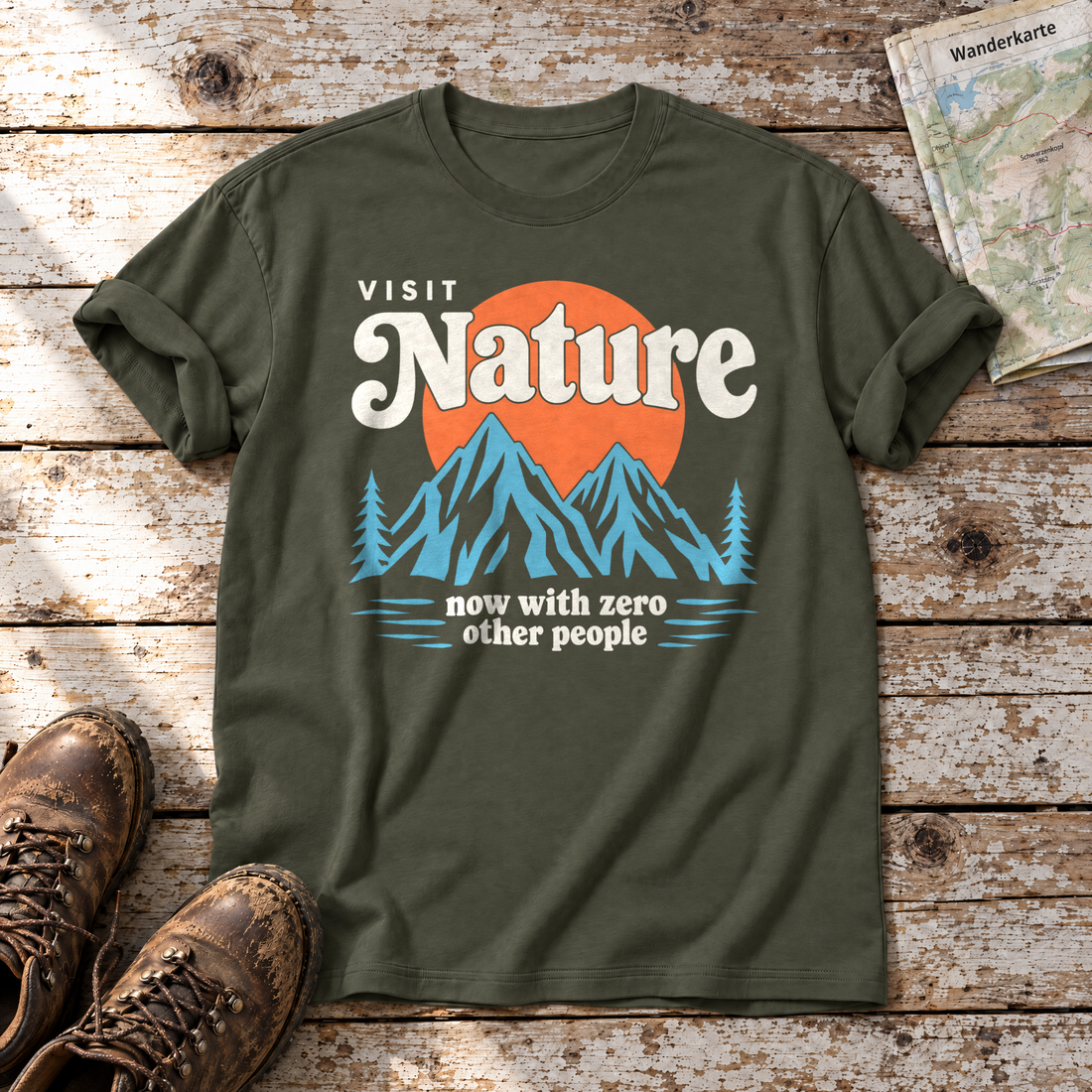 Now with zero other people – T-Shirt Unisex in Oliv, flach liegend auf alten Holzbrettern mit Wanderschuhen und Wanderkarte.