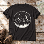 Nowhere to be – T-Shirt Unisex in Schwarz, flach liegend auf alten Holzbrettern mit Wanderschuhen und Wanderkarte.