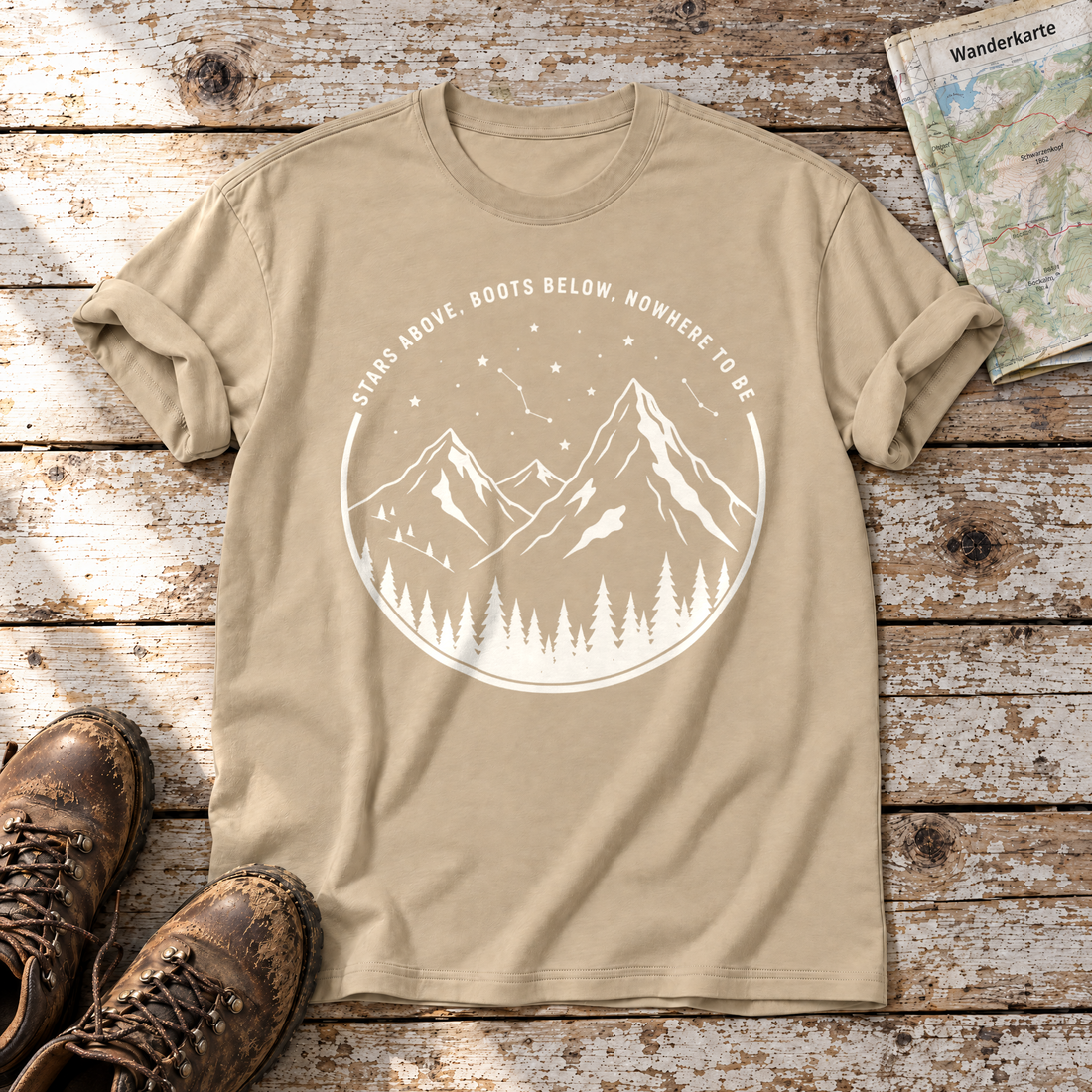 Nowhere to be – T-Shirt Unisex in Sand, flach liegend auf alten Holzbrettern mit Wanderschuhen und Wanderkarte.