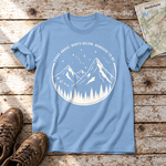 Nowhere to be – T-Shirt Unisex in Himmelblau, flach liegend auf alten Holzbrettern mit Wanderschuhen und Wanderkarte.