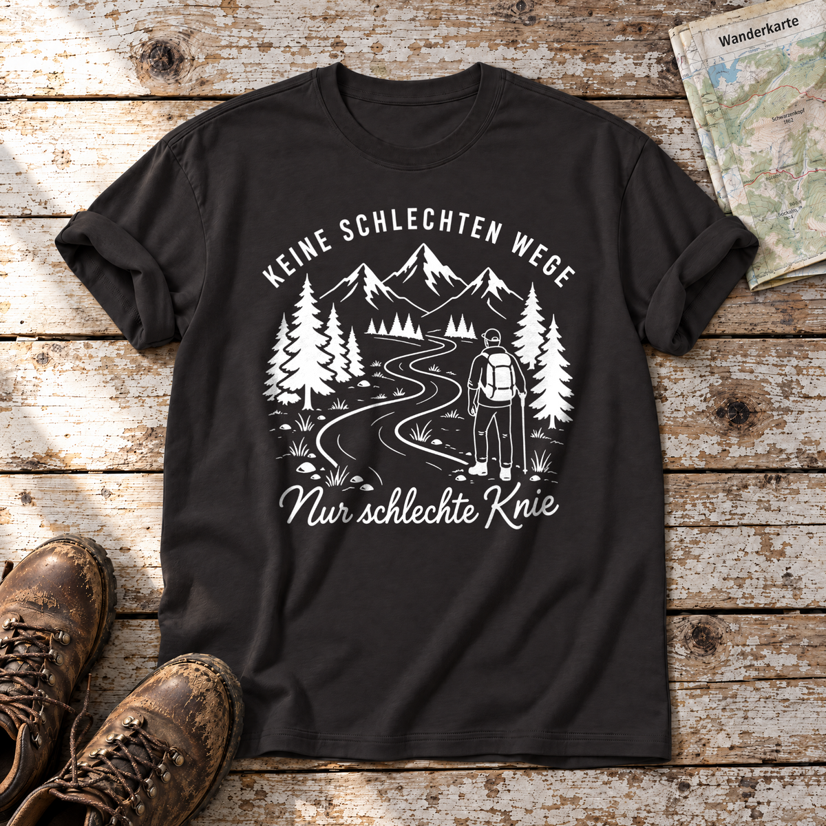 Nur schlechte Knie – T-Shirt Unisex in Schwarz, flach liegend auf alten Holzbrettern mit Wanderschuhen und Wanderkarte.