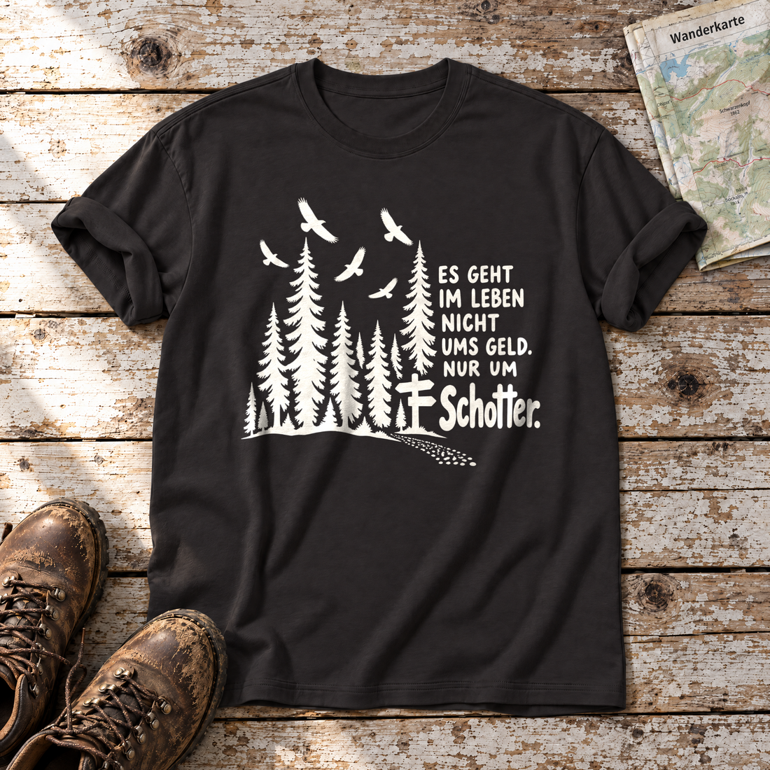 Nur um Schotter – T-Shirt Unisex in Schwarz, flach liegend auf alten Holzbrettern mit Wanderschuhen und Wanderkarte.