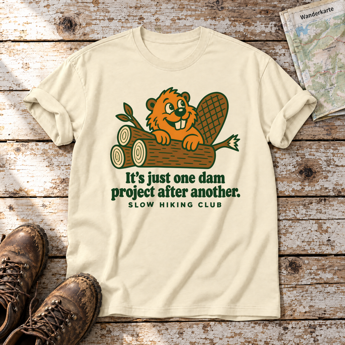 One dam project after another – T-Shirt Unisex in Natur, flach liegend auf alten Holzbrettern mit Wanderschuhen und Wanderkarte.