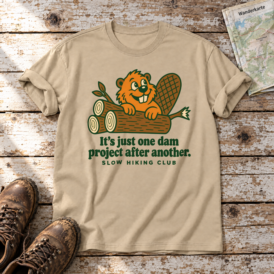 One dam project after another – T-Shirt Unisex in Sand, flach liegend auf alten Holzbrettern mit Wanderschuhen und Wanderkarte.
