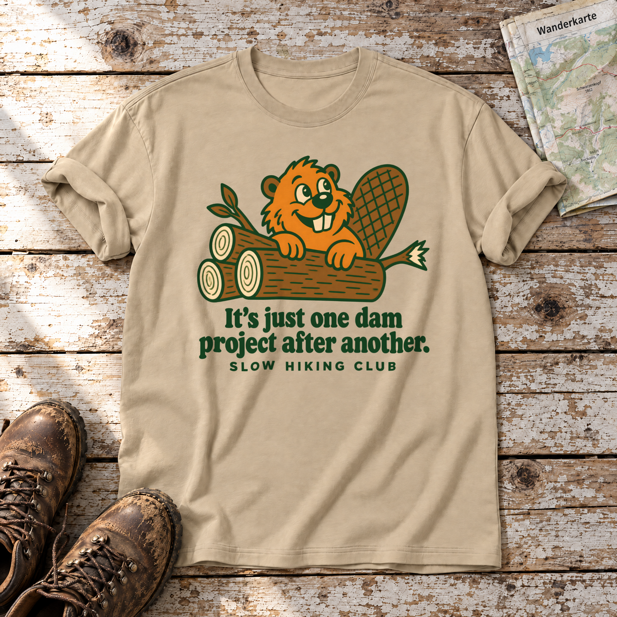 One dam project after another – T-Shirt Unisex in Sand, flach liegend auf alten Holzbrettern mit Wanderschuhen und Wanderkarte.
