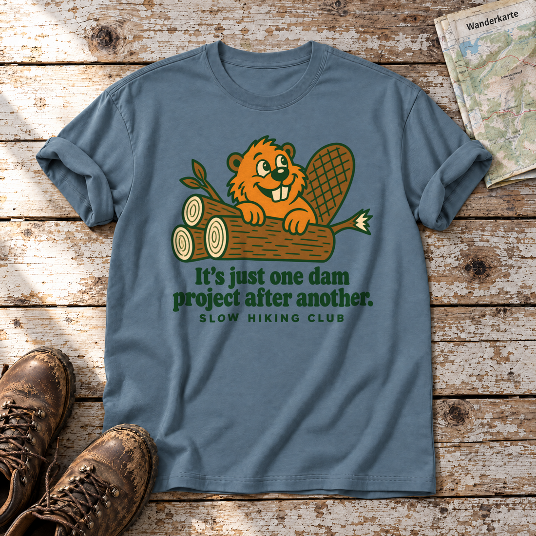 One dam project after another – T-Shirt Unisex in Steinblau, flach liegend auf alten Holzbrettern mit Wanderschuhen und Wanderkarte.