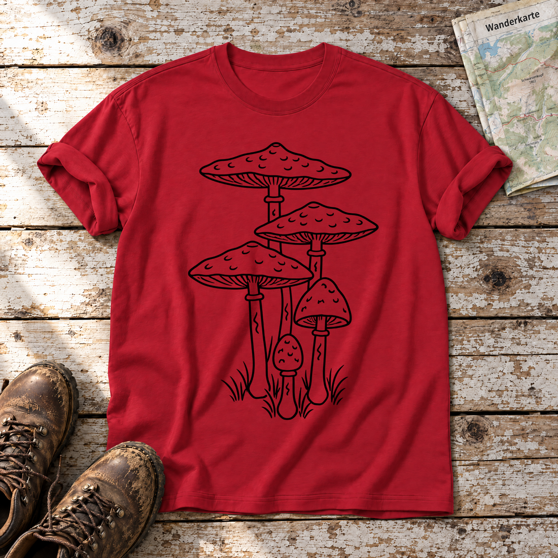 Parasolpilze – T-Shirt Unisex in Rot, flach liegend auf alten Holzbrettern mit Wanderschuhen und Wanderkarte.