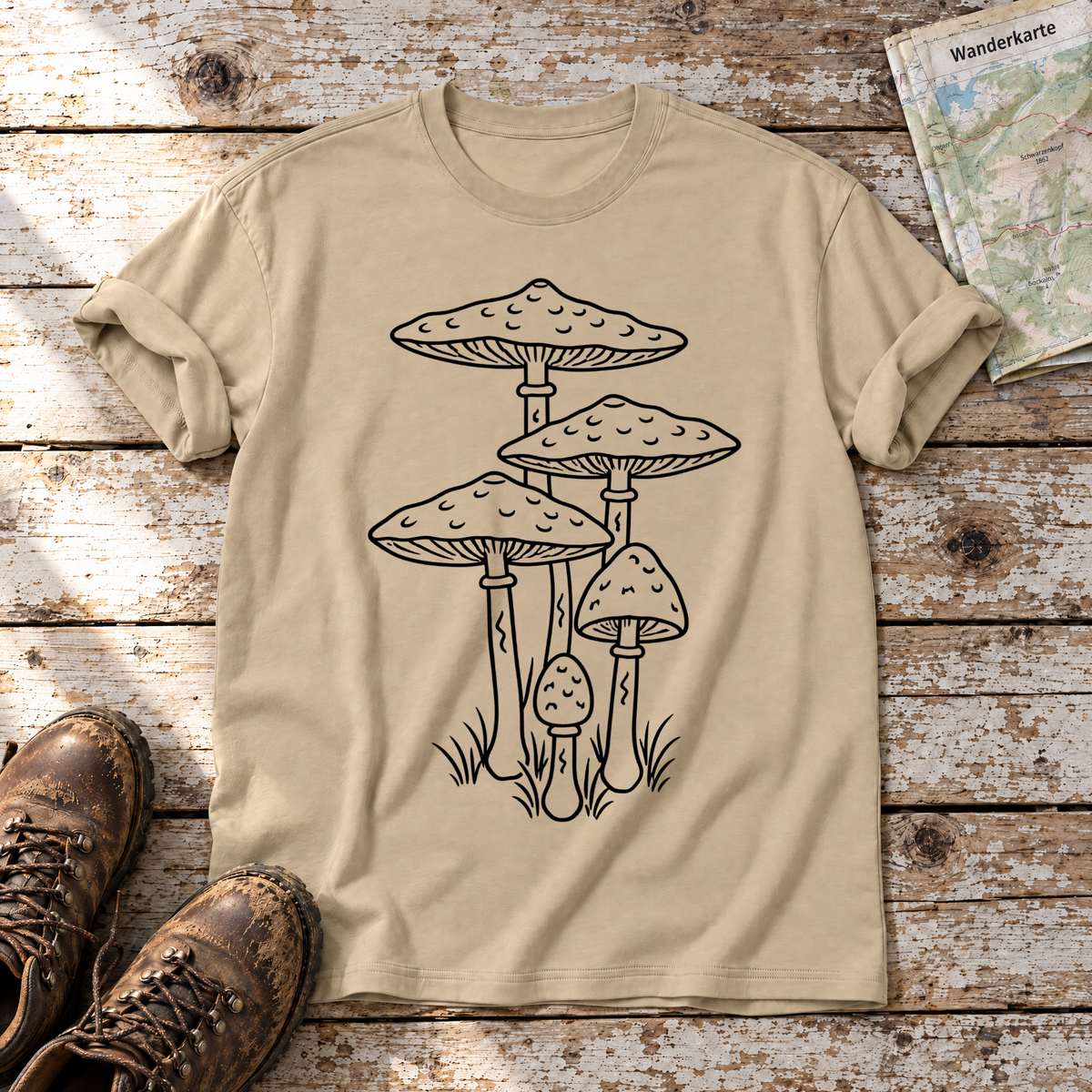 Parasolpilze – T-Shirt Unisex in Sand, flach liegend auf alten Holzbrettern mit Wanderschuhen und Wanderkarte.