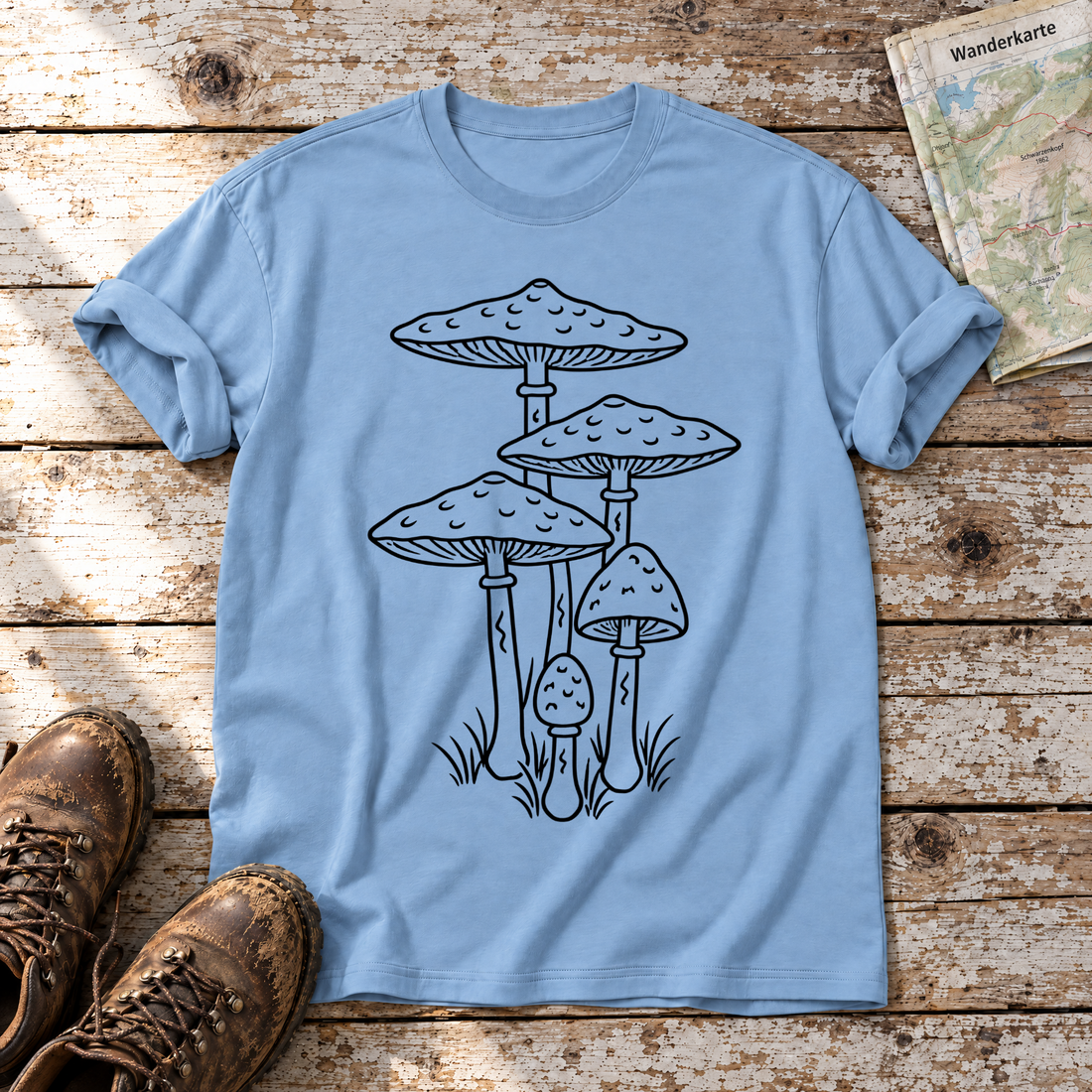 Parasolpilze – T-Shirt Unisex in Himmelblau, flach liegend auf alten Holzbrettern mit Wanderschuhen und Wanderkarte.