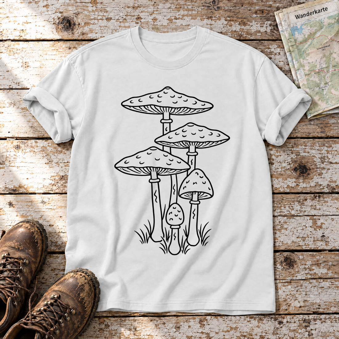 Parasolpilze – T-Shirt Unisex in Weiß, flach liegend auf alten Holzbrettern mit Wanderschuhen und Wanderkarte.