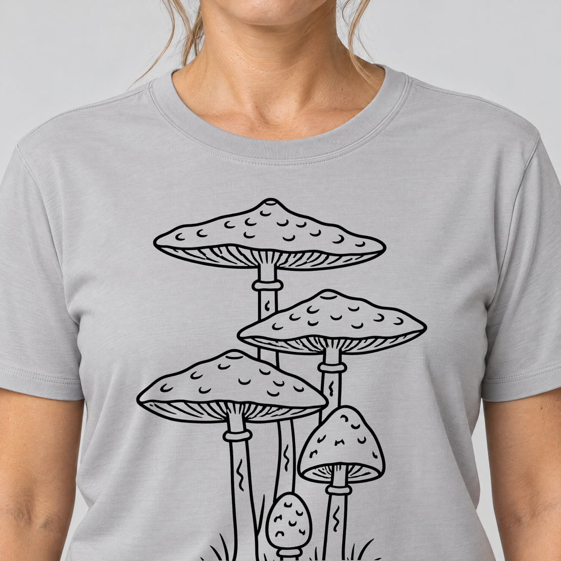 Nahaufnahme des Drucks: Parasolpilze – T-Shirt Unisex in Hellgrau, von einer Frau getragen