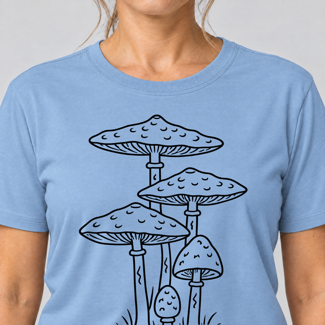 Nahaufnahme des Drucks: Parasolpilze – T-Shirt Unisex in Himmelblau, von einer Frau getragen