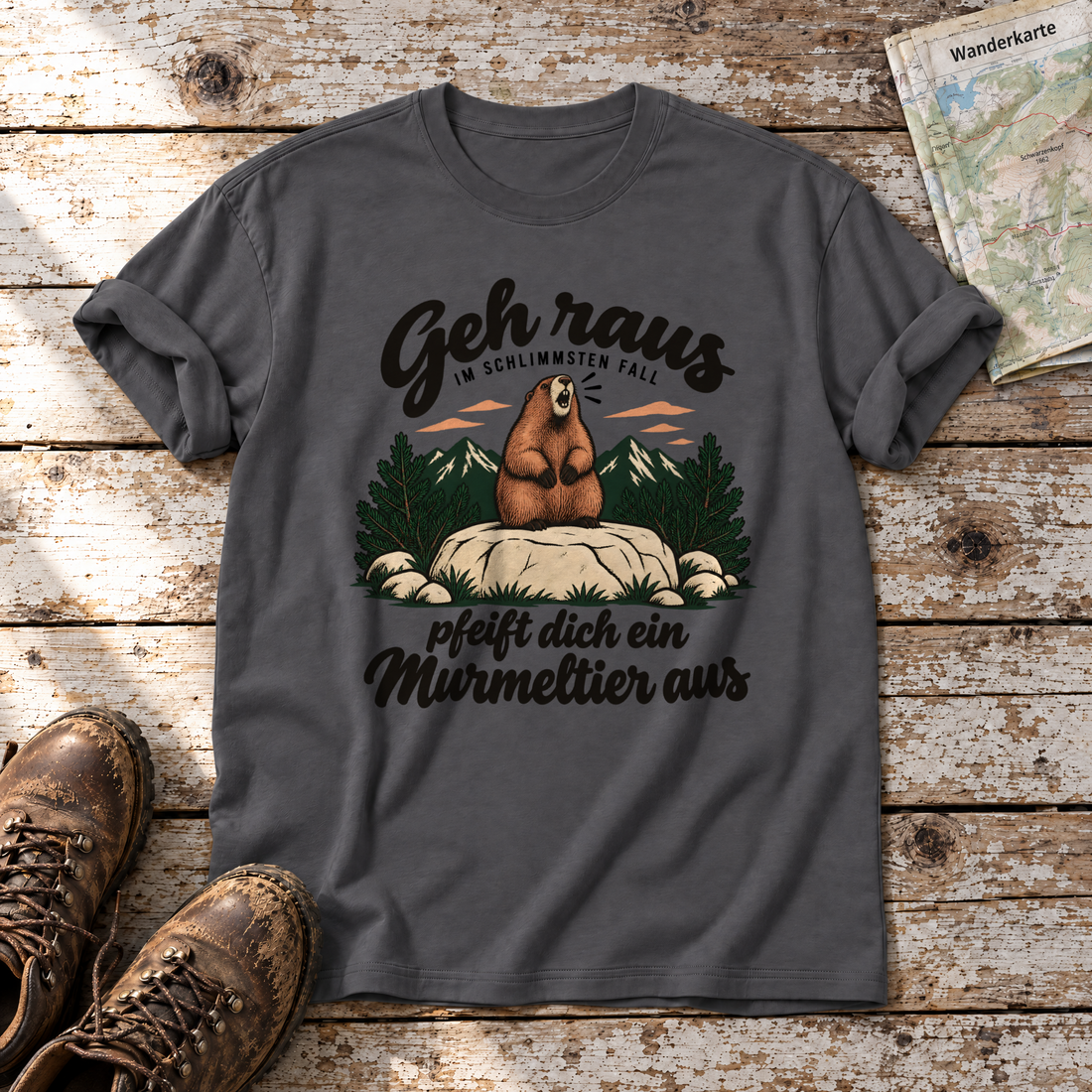 Pfeift dich ein Murmeltier aus – T-Shirt Unisex in Dunkelgrau, flach liegend auf alten Holzbrettern mit Wanderschuhen und Wanderkarte.
