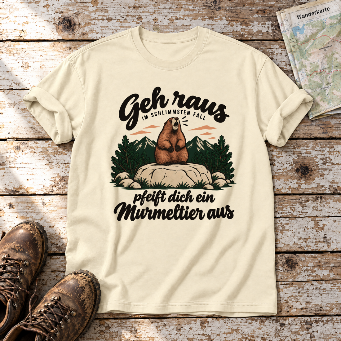 Pfeift dich ein Murmeltier aus – T-Shirt Unisex in Natur, flach liegend auf alten Holzbrettern mit Wanderschuhen und Wanderkarte.
