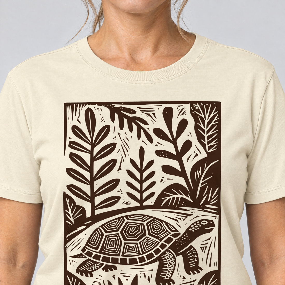 Nahaufnahme des Drucks: Schildkröte im Linolschnitt – T-Shirt Unisex in Natur, von einer Frau getragen