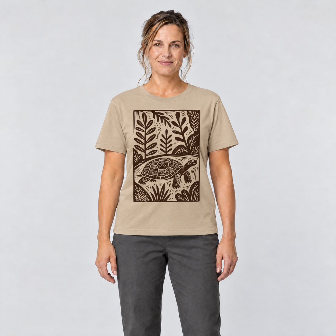 Frau trägt Schildkröte im Linolschnitt – T-Shirt Unisex in Sand, Ansicht von vorn