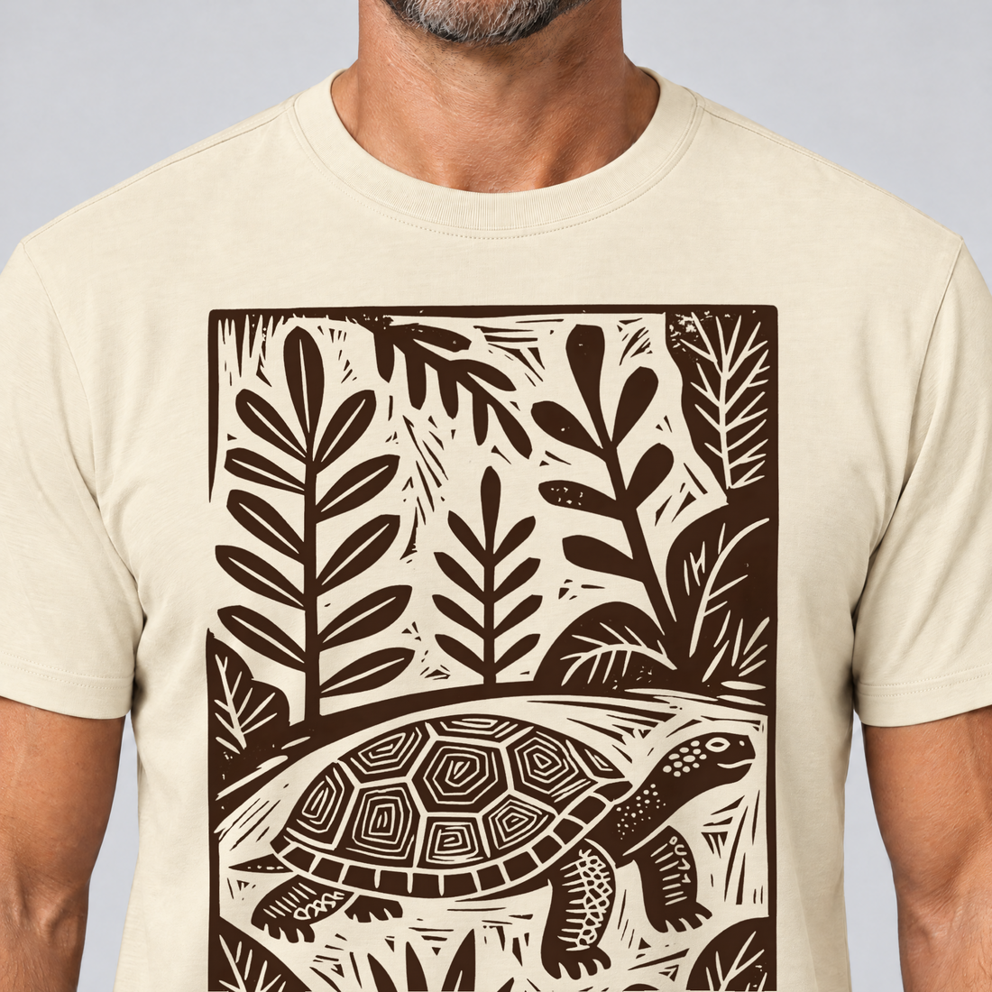 Nahaufnahme des Drucks: Schildkröte im Linolschnitt – T-Shirt Unisex in Natur, von einem Mann getragen