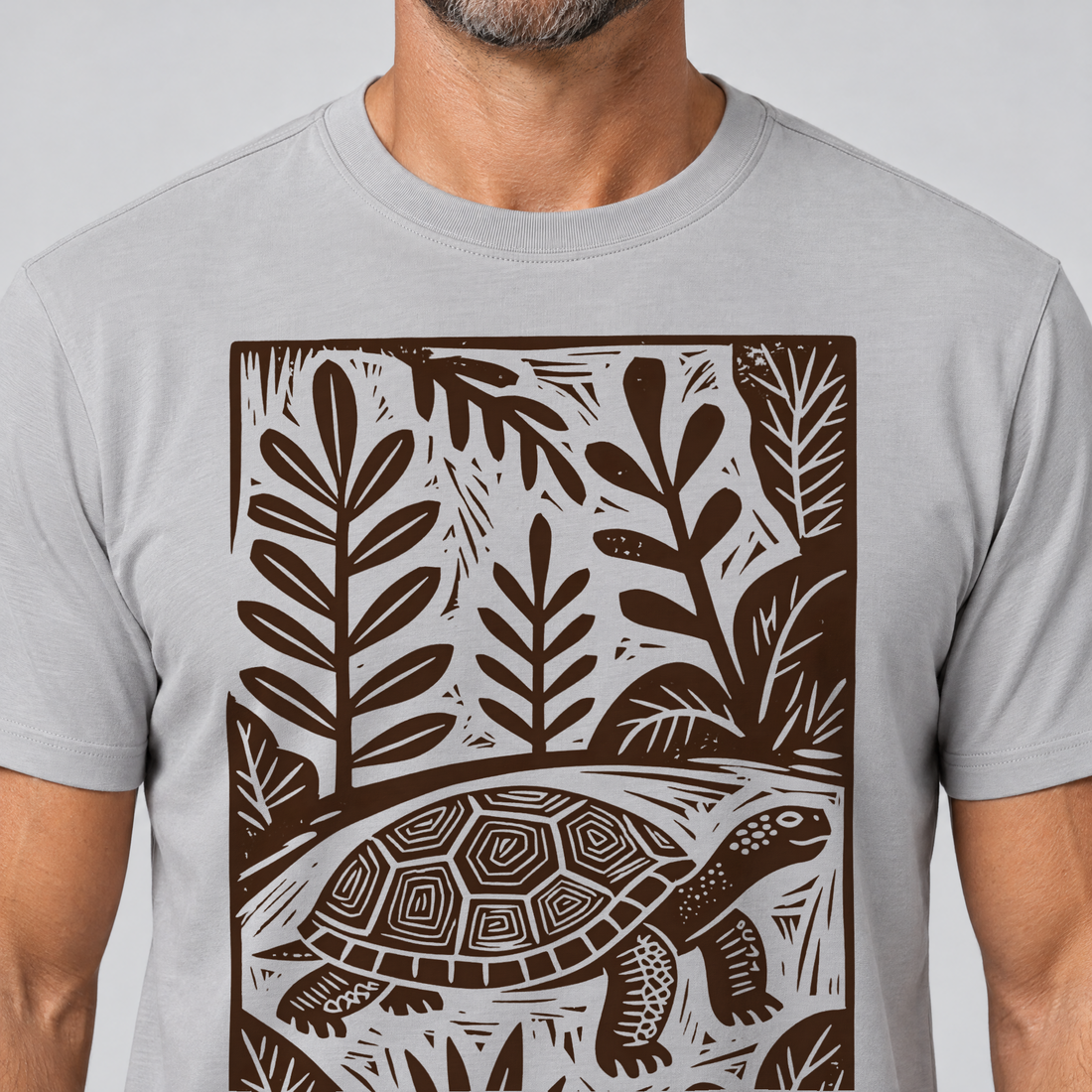 Nahaufnahme des Drucks: Schildkröte im Linolschnitt – T-Shirt Unisex in Hellgrau, von einem Mann getragen