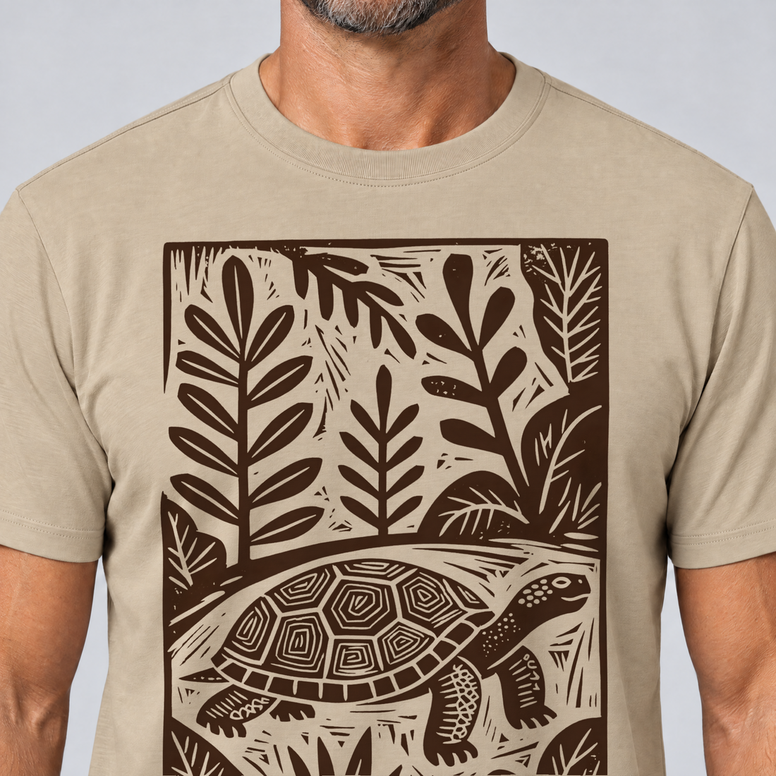 Nahaufnahme des Drucks: Schildkröte im Linolschnitt – T-Shirt Unisex in Sand, von einem Mann getragen