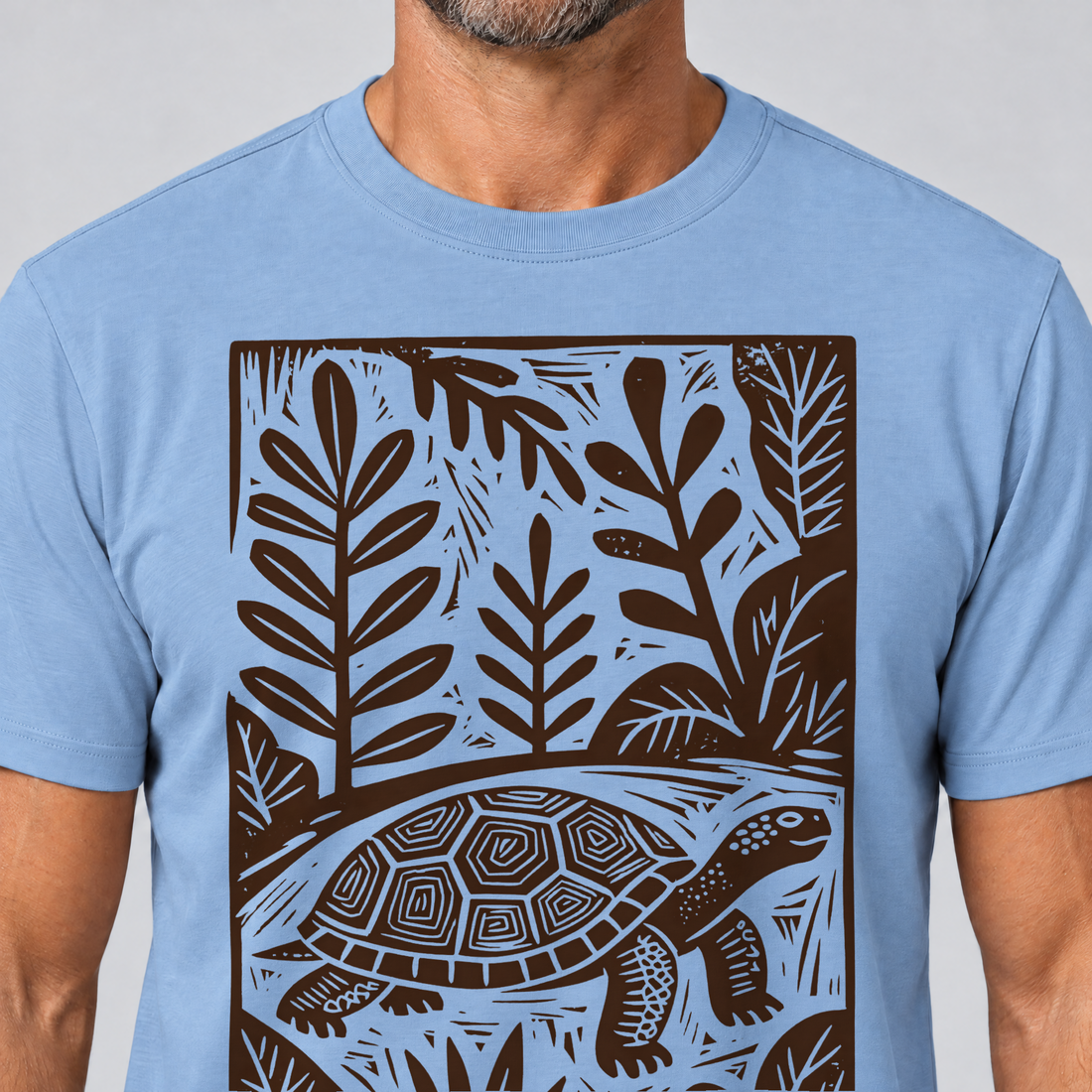 Nahaufnahme des Drucks: Schildkröte im Linolschnitt – T-Shirt Unisex in Himmelblau, von einem Mann getragen