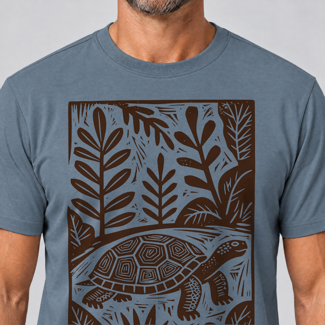 Nahaufnahme des Drucks: Schildkröte im Linolschnitt – T-Shirt Unisex in Steinblau, von einem Mann getragen