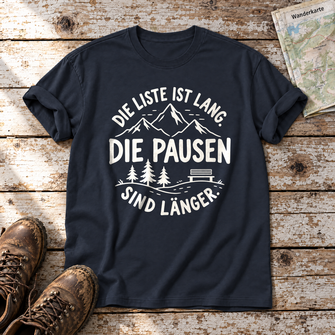 Die Pausen sind länger – T-Shirt Unisex in Navy, flach liegend auf alten Holzbrettern mit Wanderschuhen und Wanderkarte.