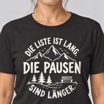 Nahaufnahme des Drucks: Die Pausen sind länger – T-Shirt Unisex in Schwarz, von einer Frau getragen