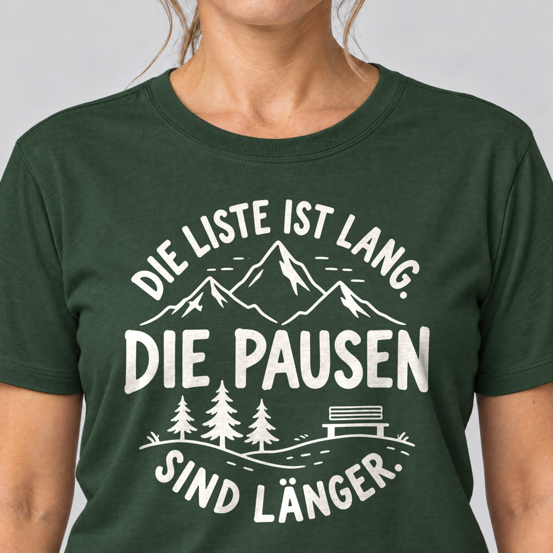 Nahaufnahme des Drucks: Die Pausen sind länger – T-Shirt Unisex in Flaschengrün, von einer Frau getragen