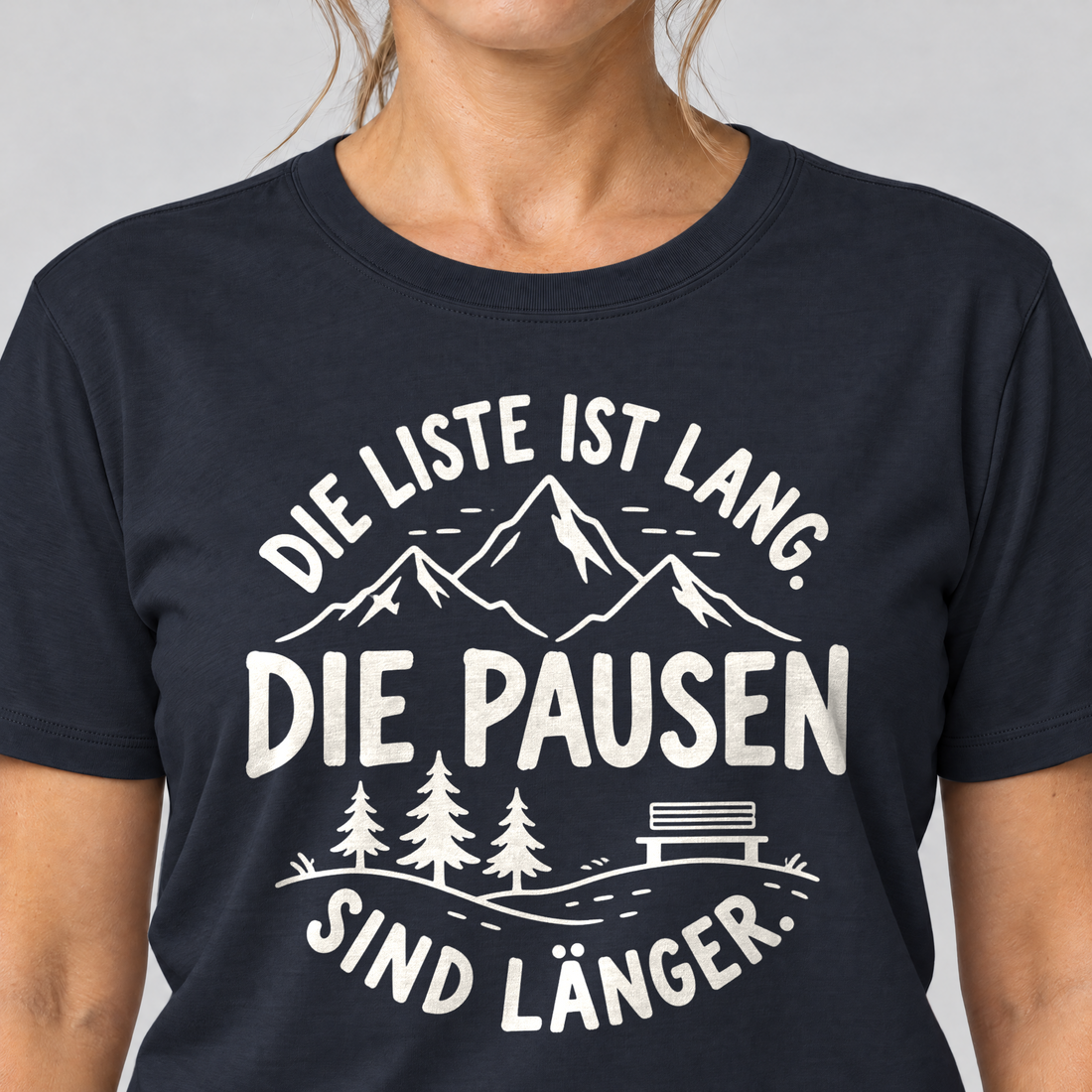 Nahaufnahme des Drucks: Die Pausen sind länger – T-Shirt Unisex in Navy, von einer Frau getragen