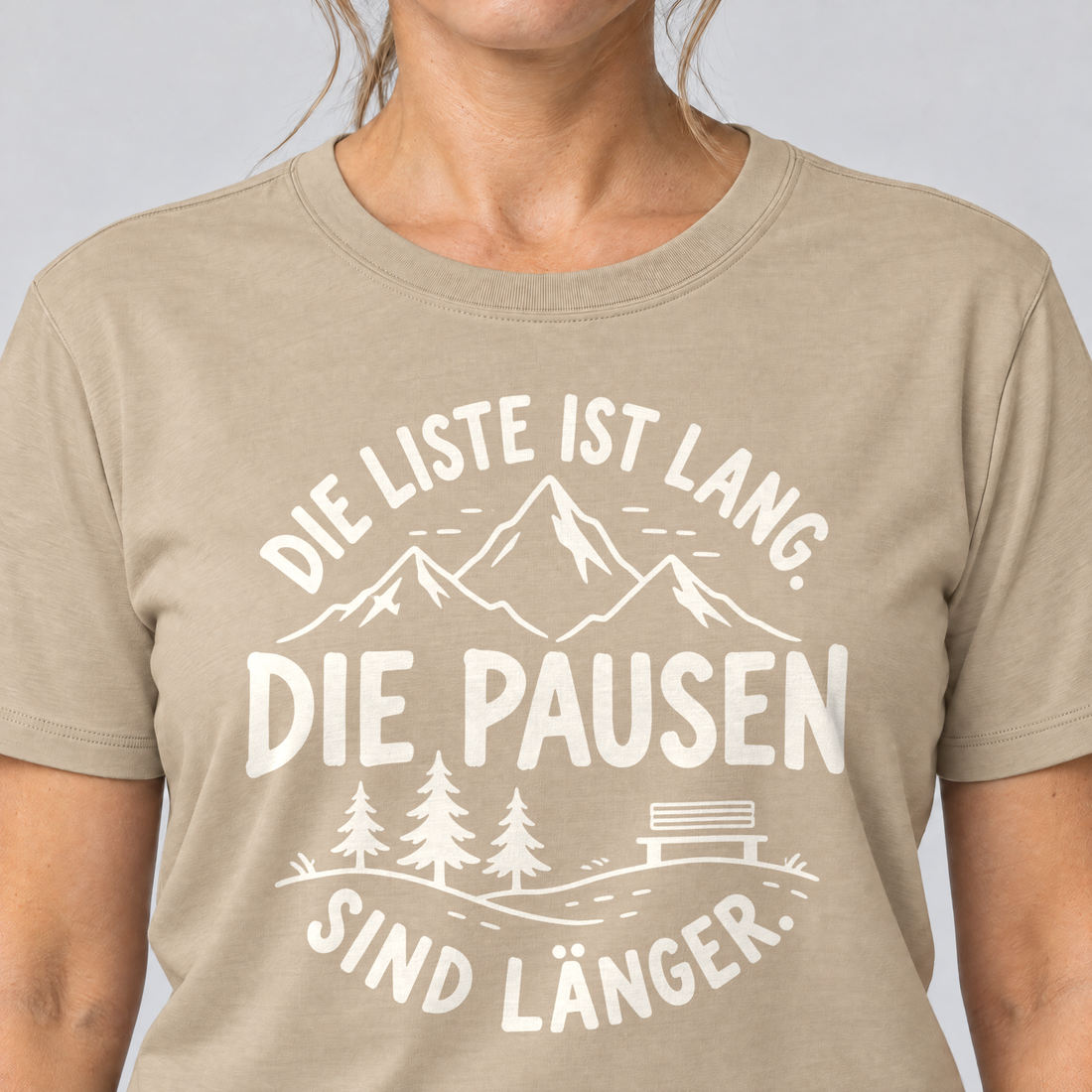 Nahaufnahme des Drucks: Die Pausen sind länger – T-Shirt Unisex in Sand, von einer Frau getragen