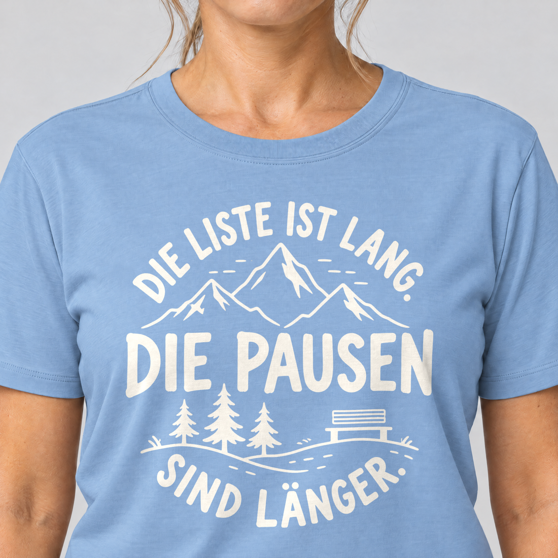 Nahaufnahme des Drucks: Die Pausen sind länger – T-Shirt Unisex in Himmelblau, von einer Frau getragen