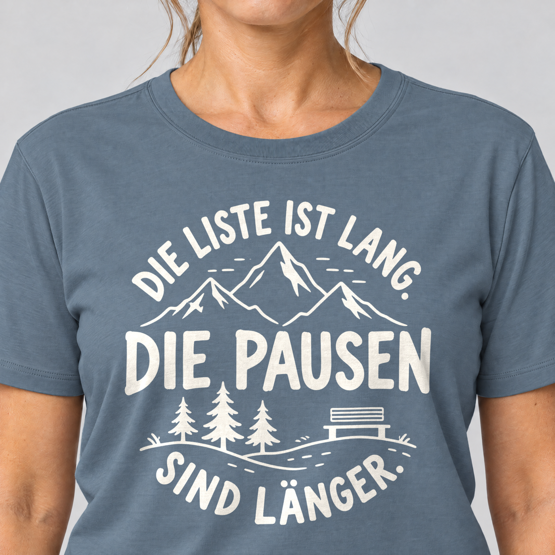 Nahaufnahme des Drucks: Die Pausen sind länger – T-Shirt Unisex in Steinblau, von einer Frau getragen